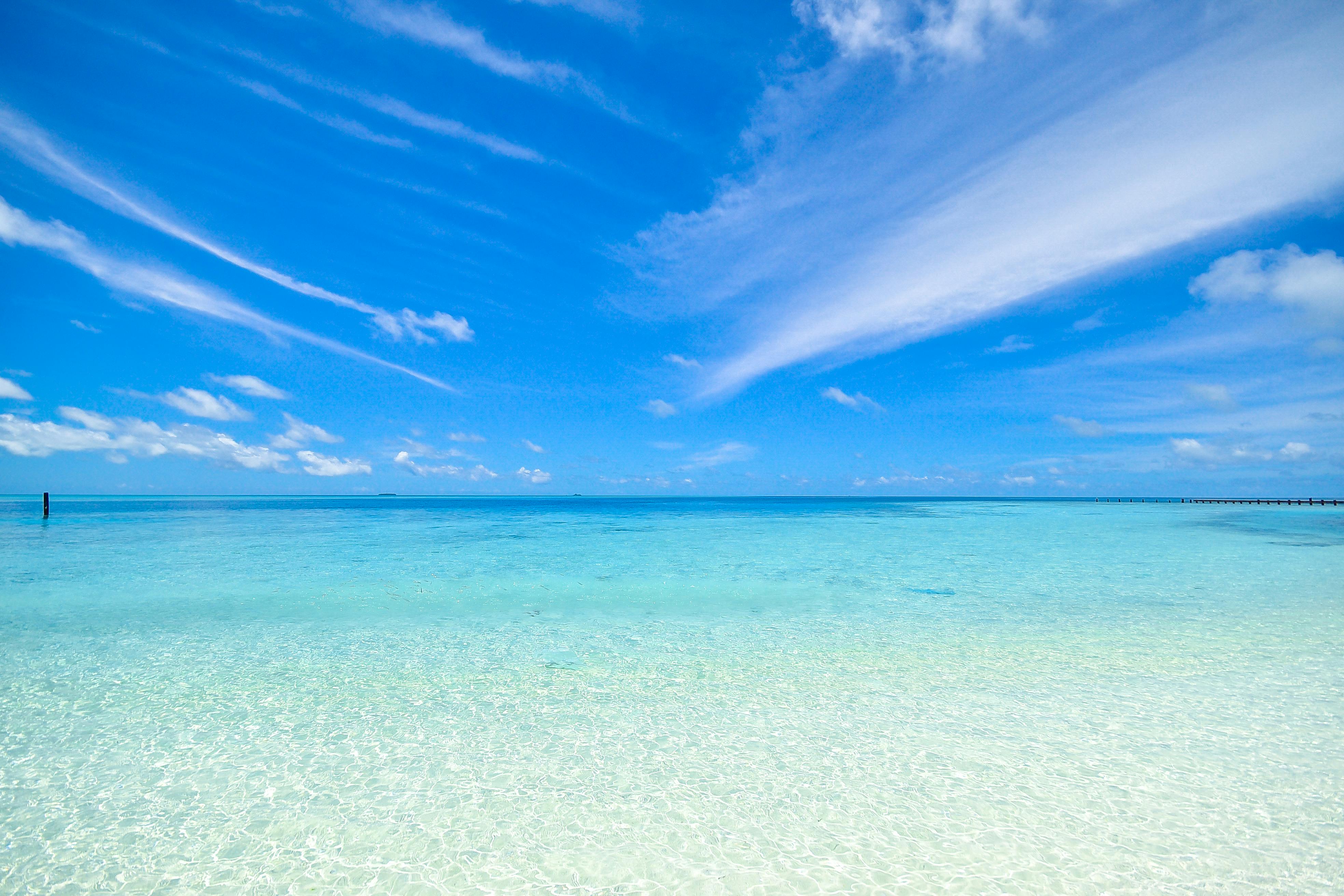 Under a clear sky, the clear sea water is light blue, the calm sea surface is calm, showing a peaceful and beautiful picture. - free wallpaper image