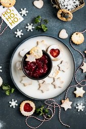 Assorted Christmas cookies with some strawberry jam, string and snowflake decoration beside. - wallpaper image