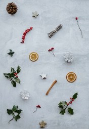 A gray background with some Christmas decorations, including pinecones, twigs, orange slices, stars and berries. - wallpaper image