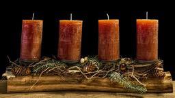 Four brown candles are placed on a wooden base, decorated with branches and pine cones. - wallpaper image