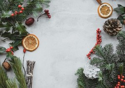 A gray background image with Christmas elements, including pine branches, red berries, orange peels, pine cones and so on. - wallpaper image