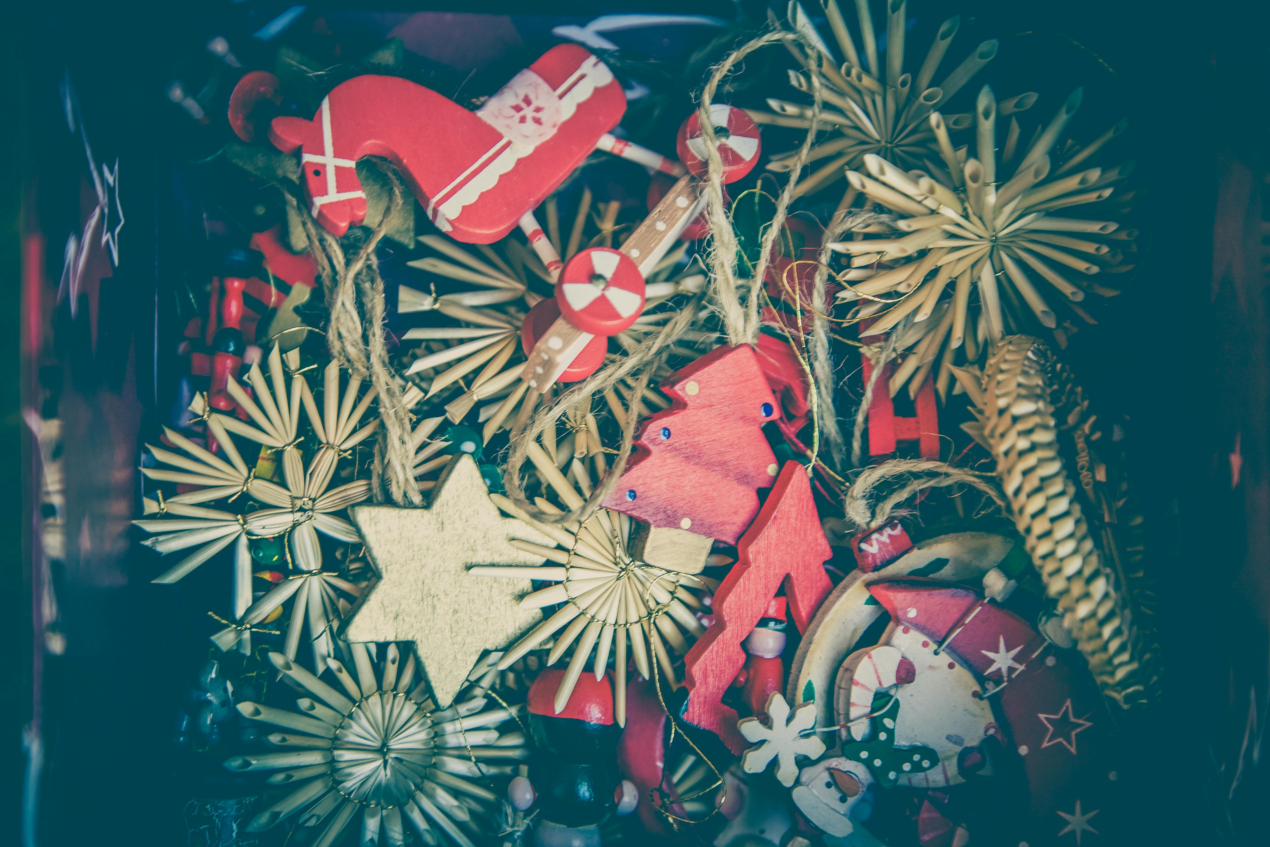 A box full of various Christmas ornaments, including wooden Christmas trees, stars, horses, and other decorations. - wallpaper image