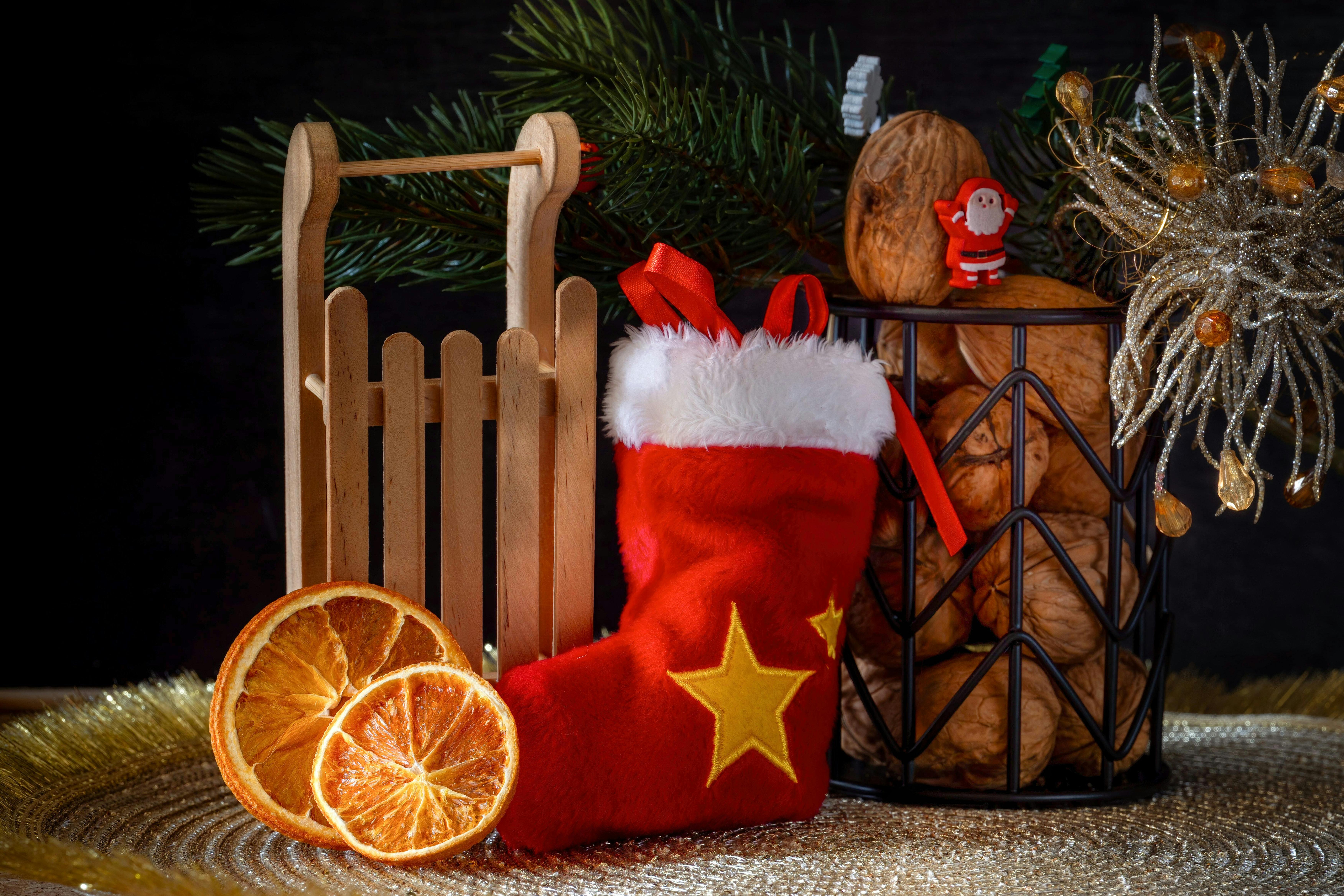 A still life photo with Christmas theme, there are Christmas stockings, dried orange slices, nuts and Christmas decorations. - wallpaper image