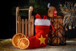 A still life photo with Christmas theme, there are Christmas stockings, dried orange slices, nuts and Christmas decorations. - wallpaper image