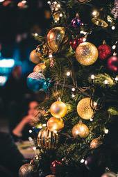 A close-up shot of a Christmas tree decorated with colorful baubles and twinkling lights. - wallpaper image