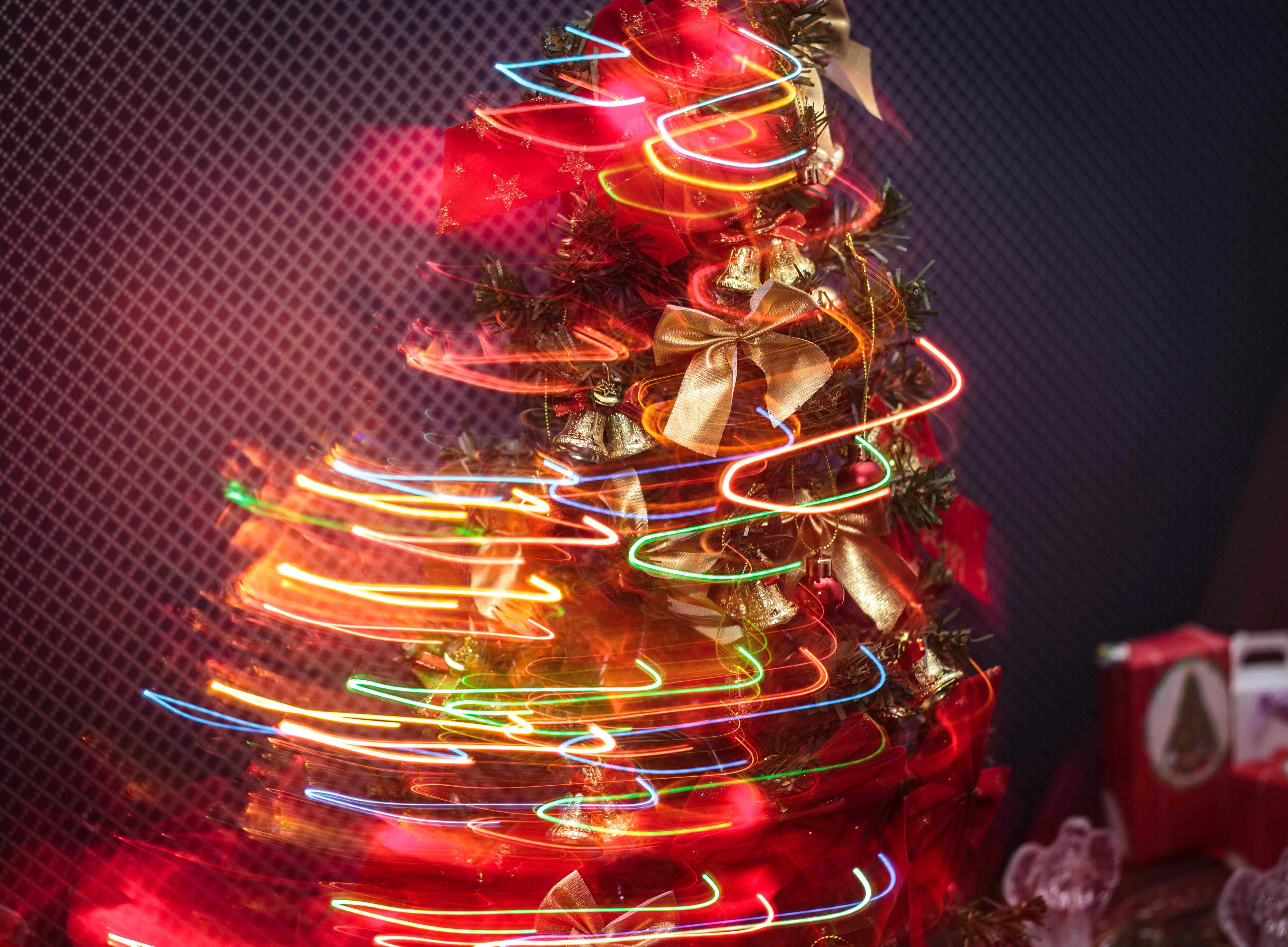 A Christmas tree with colorful lights, creating a festive atmosphere. - wallpaper image