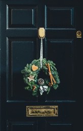 A black door decorated with a Christmas wreath, the wreath is decorated with some ornaments like pine cones, cinnamon sticks and a heart-shaped gingerbread - wallpaper image