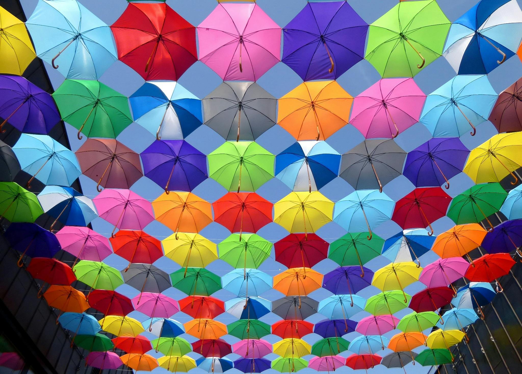 Many colorful umbrellas hang in the air, forming a dazzling array of colors - free wallpaper image