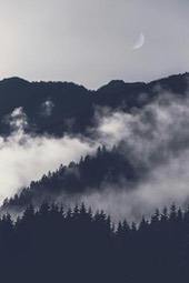 A thick fog covers the mountaintop, with a crescent moon in the sky, the picture presents a mysterious and tranquil atmosphere. - free wallpaper image