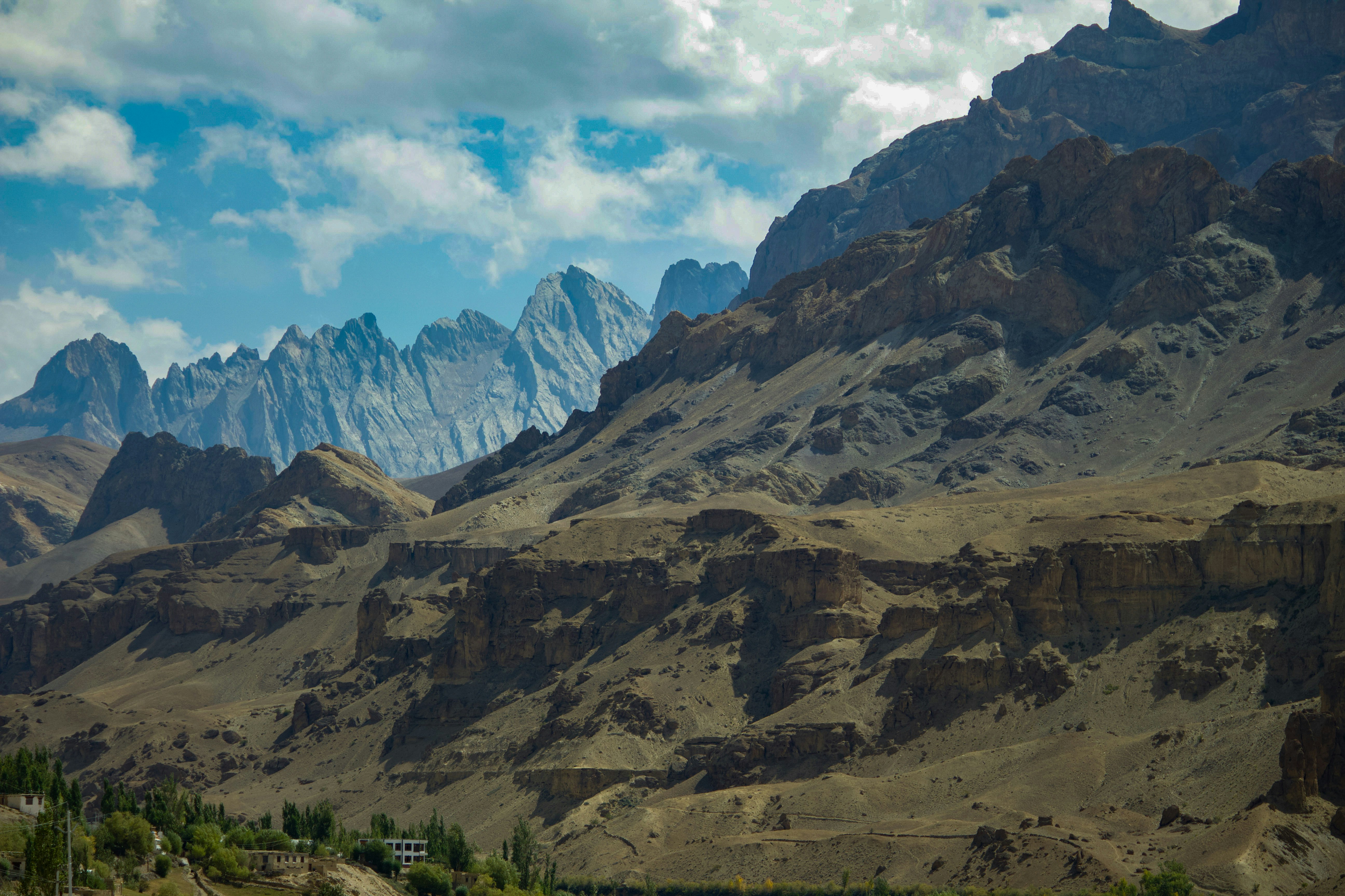 The distant mountains are particularly magnificent against the backdrop of blue sky and white clouds, and at the foot of the mountains is a desolate Gobi Desert. - free wallpaper image