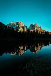 The mountain peaks are reflected in the calm lake, the sky is a refreshing blue. - free wallpaper image