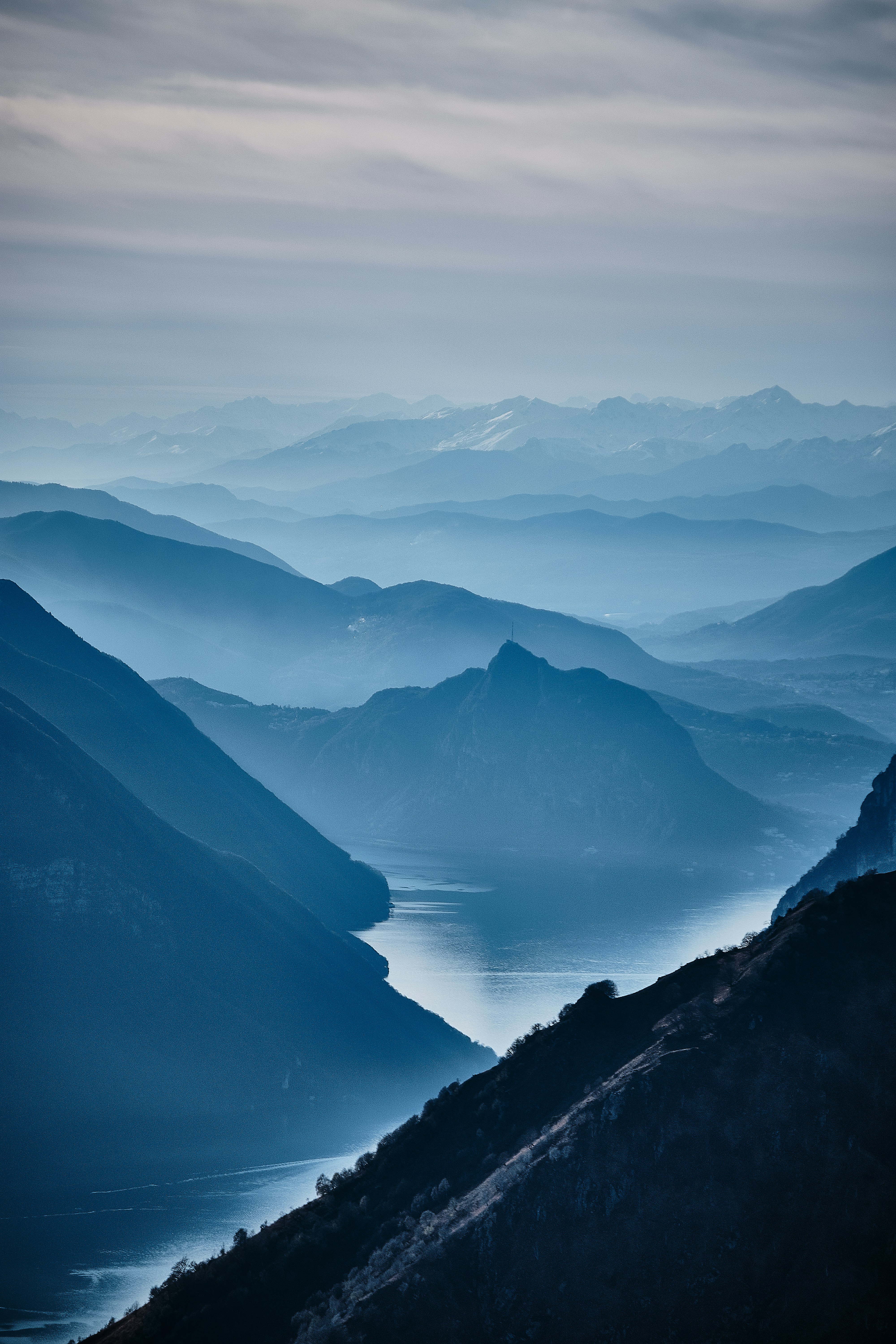 The mountains in the distance are layered, the peaks are faintly visible in the mist, and the river winds through the mountains. - free wallpaper image