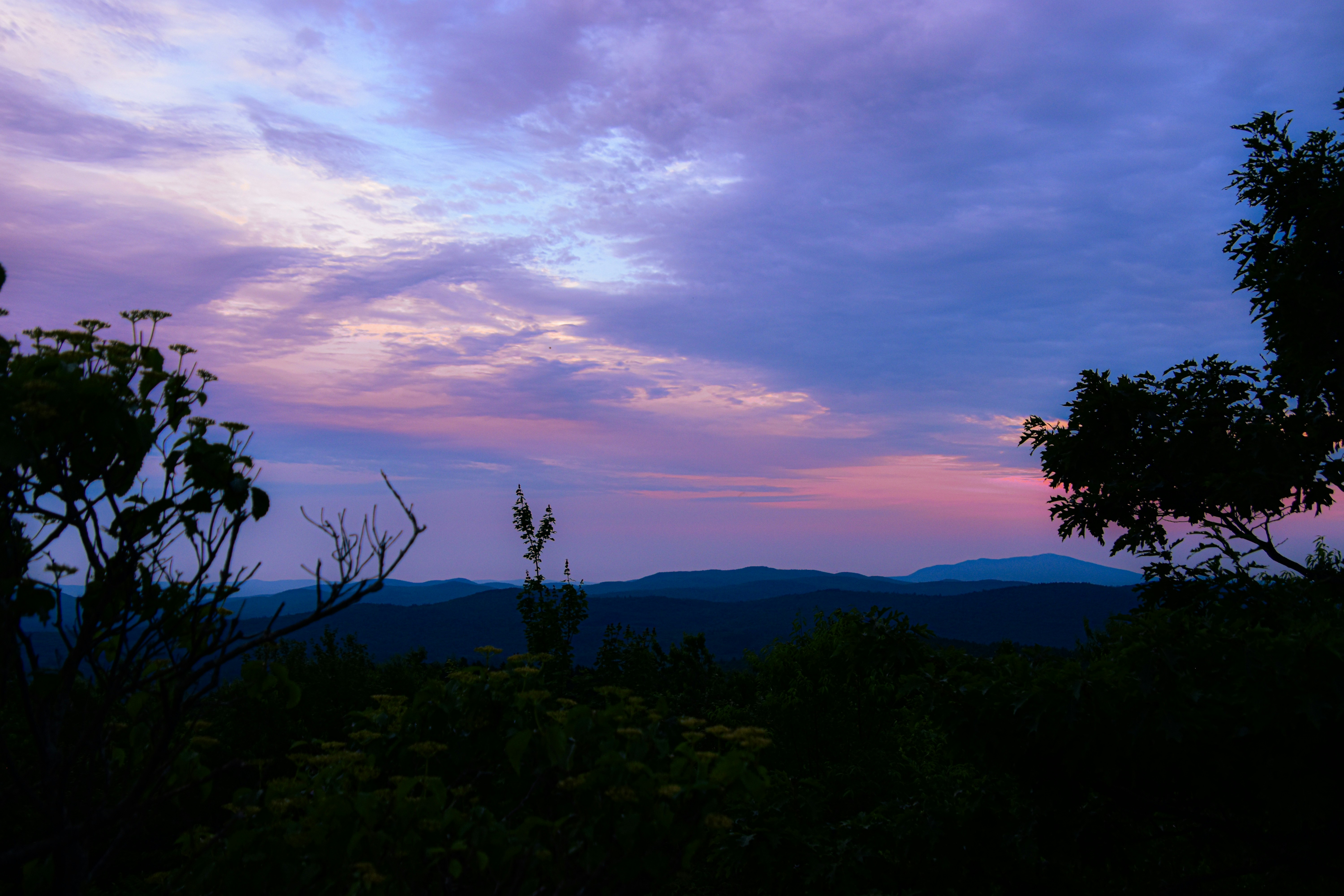 Sunrise from a mountain top, the sky is dyed pink and purple, and the distant mountains are shrouded in mist. - free wallpaper image