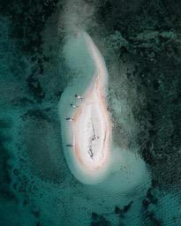 An overhead view of a beach, a white sandbar stretches into the sea, the water is a clear blue and green, there are some people on the beach. - free wallpaper image