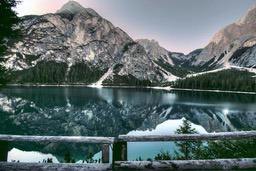 A peaceful lake reflects the majestic mountains, surrounded by lush forests, the scene is quiet and beautiful. - free wallpaper image