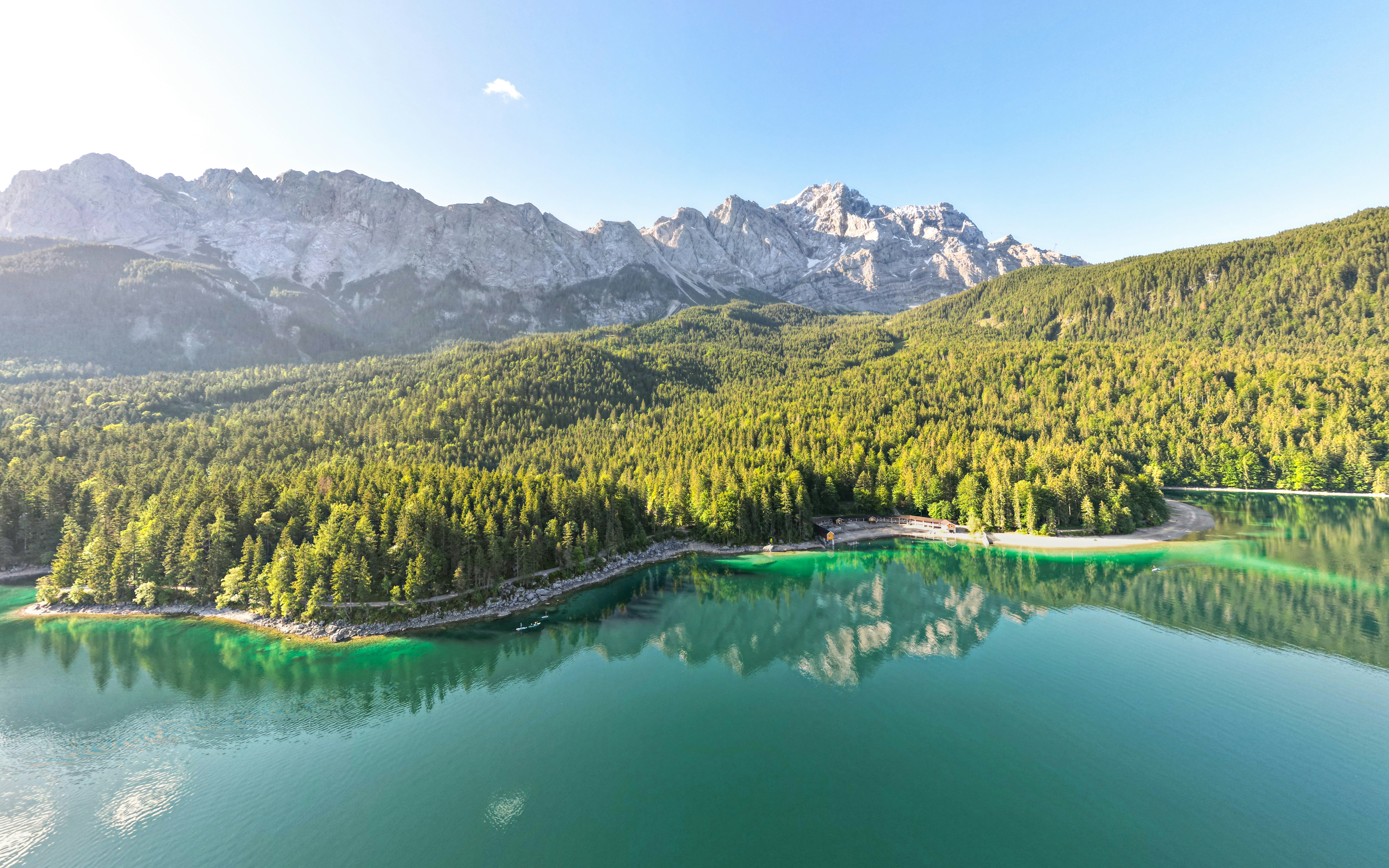 A beautiful lake with clear water, reflecting the surrounding mountains and forests, a picturesque view. - free wallpaper image