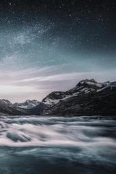 A river rushes through the mountains under a starry night sky. - free wallpaper image