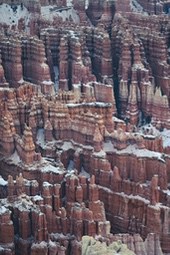 A unique natural landscape of red rock cliffs covered with white snow. - free wallpaper image