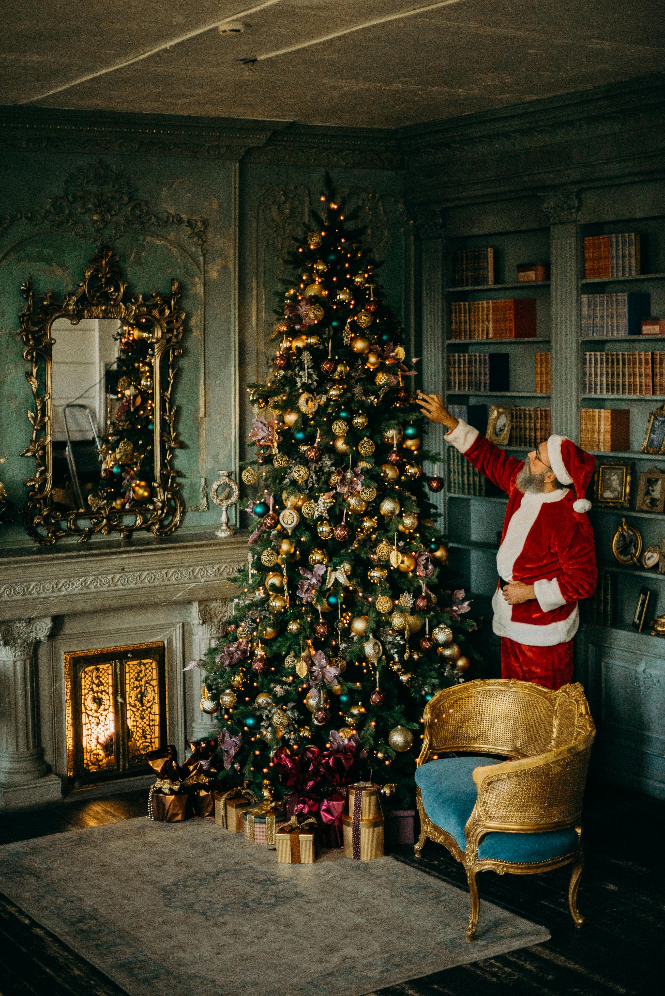 Santa Claus is decorating a Christmas tree in a beautifully decorated room, the tree is adorned with colorful lights and ornaments, the room also has a fireplace and bookshelf, full of festive atmosphere. - wallpaper image