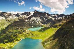 Two turquoise lakes are nestled between towering mountains, the peaks are covered with snow, the sky is clear and white clouds are floating. - free wallpaper image