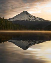 The morning sun shines on the snowy mountain peak, and the mountain is reflected in the calm lake, forming a beautiful reflection. - free wallpaper image