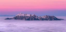 The top of the mountain is covered with white snow, the sea of clouds is surging, the sky is a dreamy pink and purple, and the distant sky is a deep blue. - free wallpaper image