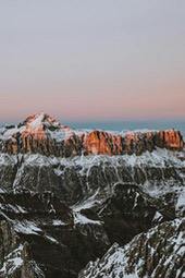 The distant mountains are dyed pink by the setting sun, the peaks are covered with white snow, the whole picture is full of tranquility and grandeur. - free wallpaper image