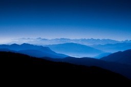 Distant mountains are layered under a blue sky, with snow-capped peaks, the scene is magnificent and beautiful. - free wallpaper image