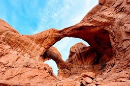 Two giant natural arches stand out against the backdrop of blue sky and white clouds. - free wallpaper image