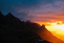 The sun sets, the clouds are dyed orange-red, and the silhouette of the mountains is particularly magnificent against the sky. - free wallpaper image