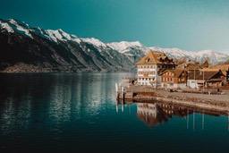 A lakeside town nestled amongst mountains, with beautiful scenery and well-arranged buildings. - free wallpaper image